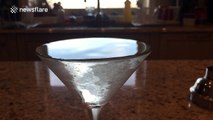 Slow-motion footage of a drop of Vermouth rippling through a Martini cocktail