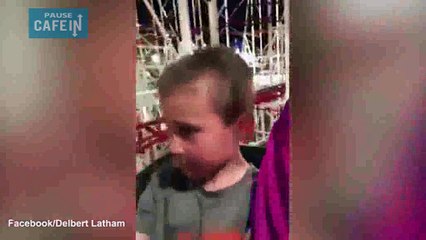 Un père rattrape son fils sur le point de tomber d'un manège