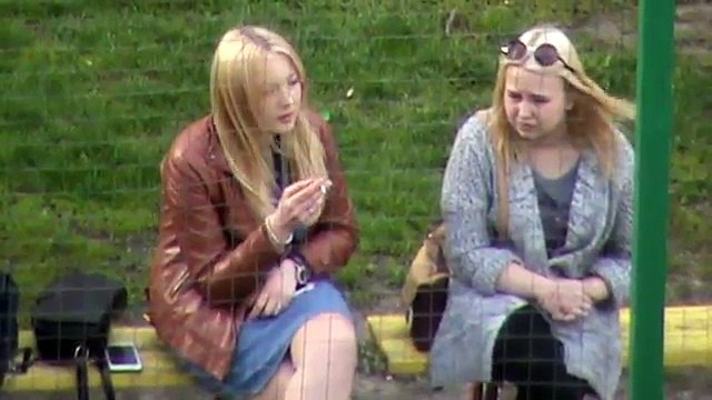 Две блондинки девушки отдыхают на лавке во дворе