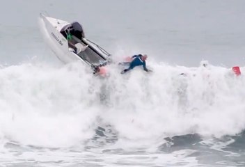 Une vague retourne un bateau rempli de surfeurs