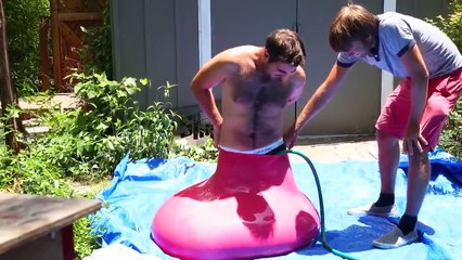 Homem entra dentro de balão de água gigante e brinca