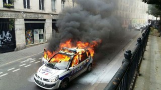 Une voiture de police brûlée par des manifestants