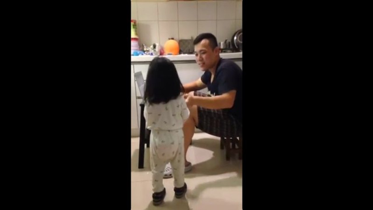 Une petite fille donne à boire à son papa