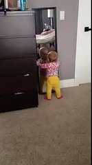 Un bébé joue avec un miroir...