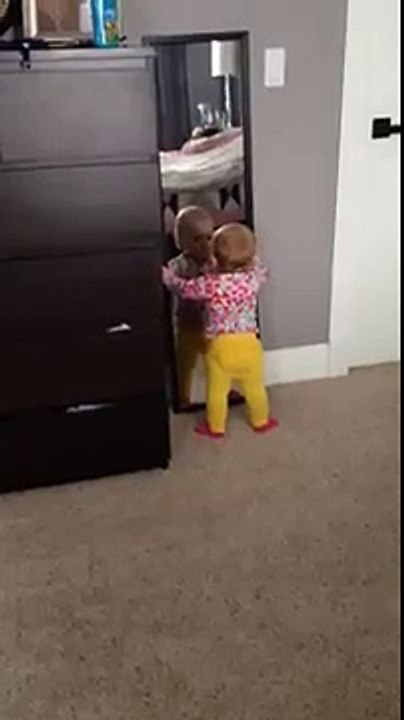 Un bébé joue avec un miroir...