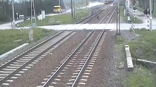Truck tries to cross train tracks with its trailer up