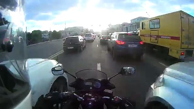 Deux voitures bloquent un motard dans un embouteillage