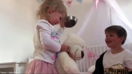 Cheeky little girl smiles as she hits brother with frying pan