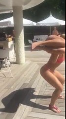 Elle fait des squats avec une fille en bikini sur les épaules