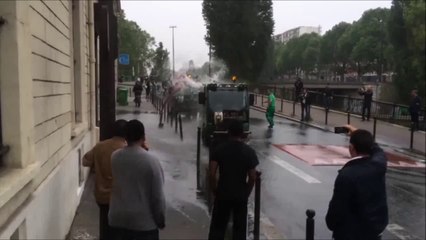 Un agent de la ville de Paris se bat avec un tuyau d'arrosage