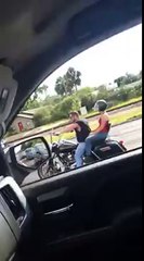 Un automobiliste roule sur une moto en plein embouteillage