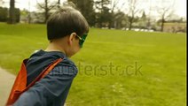 stock footage superhero boy runs around park pretending to fly