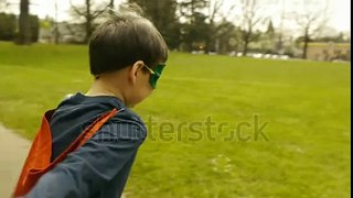 stock footage superhero boy runs around park pretending to fly