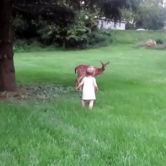 Une petite fille sympathise avec une petite biche