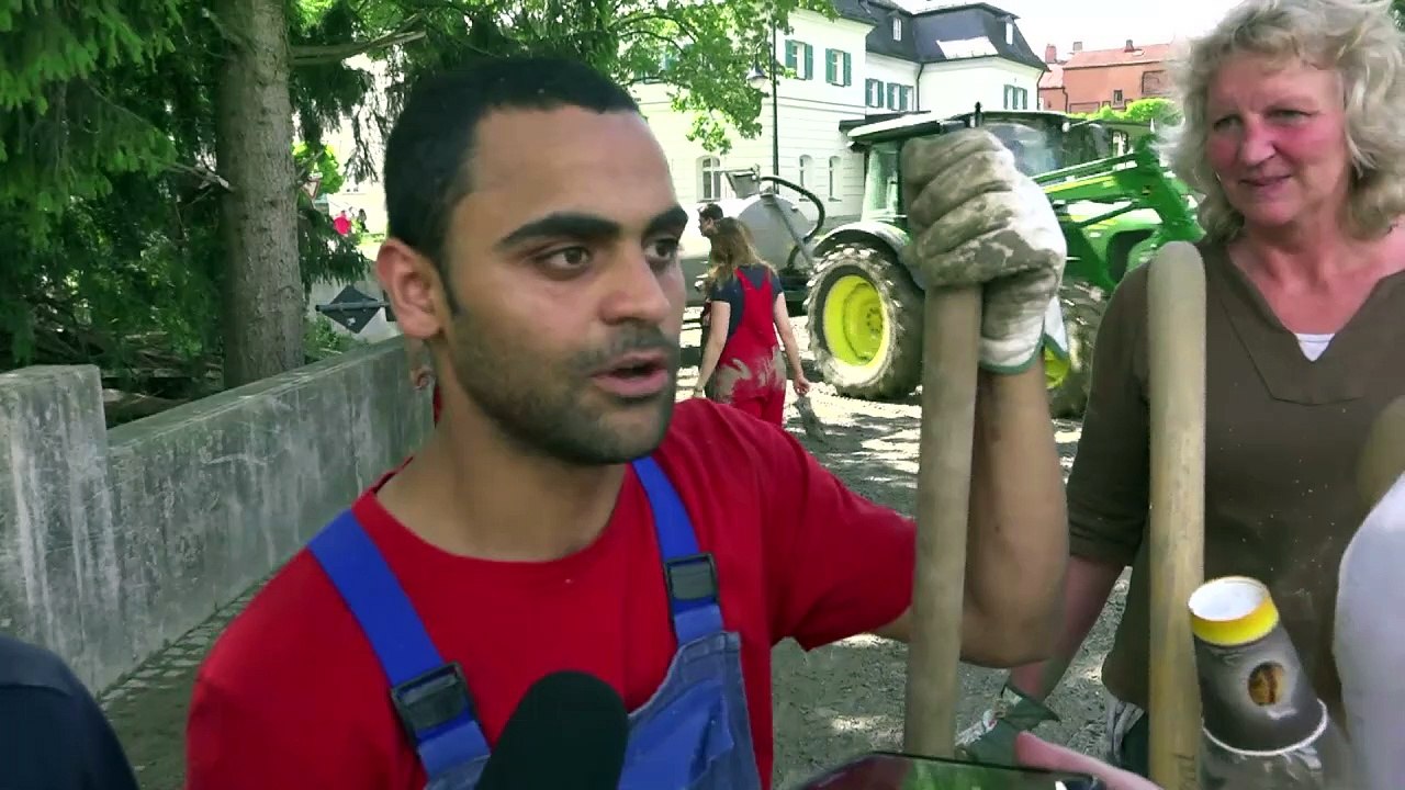 Flüchtlinge und Seehofer bei Aufräumarbeiten in Niederbayern
