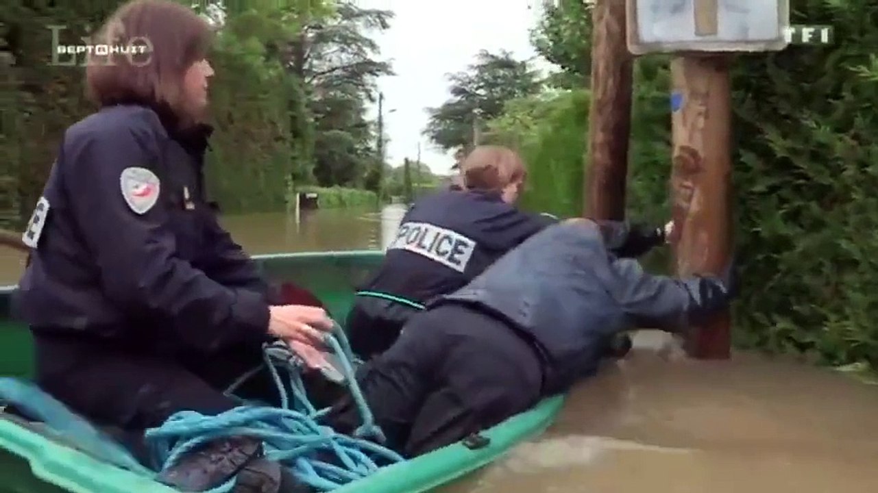 Des policiers sur un bateau pendant les inondations