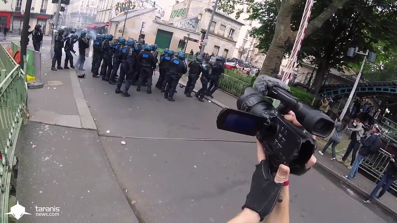 Un CRS fait du foot pendant une manifestation
