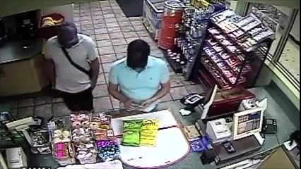 Il est en face de la caissière, mais regardez ce que fait son complice !