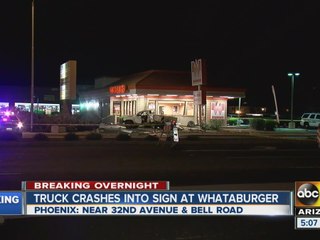 Truck crashes into sign at Whataburger