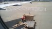 Un employé jette les cartons à côté du chargement de l'avion
