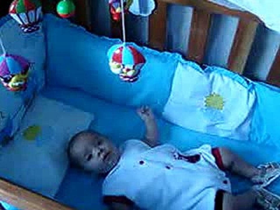 Bebê brincando no berço.