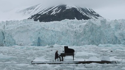 Des morceaux de glacier s'effondre derrière un pianiste