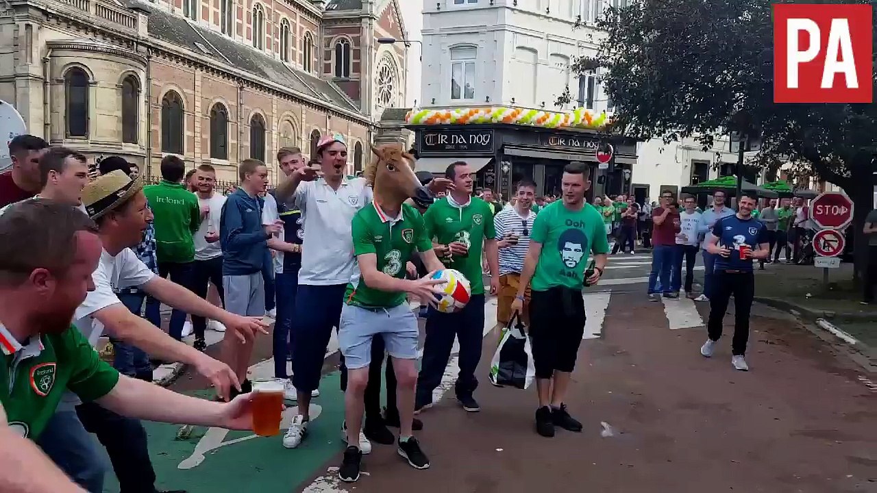 Un supporter irlandais avec une tête de cheval tire au ballon