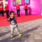 Un enfant chinois répète la chorégraphie des danseuses derrière lui et il danse très bien pour son âge