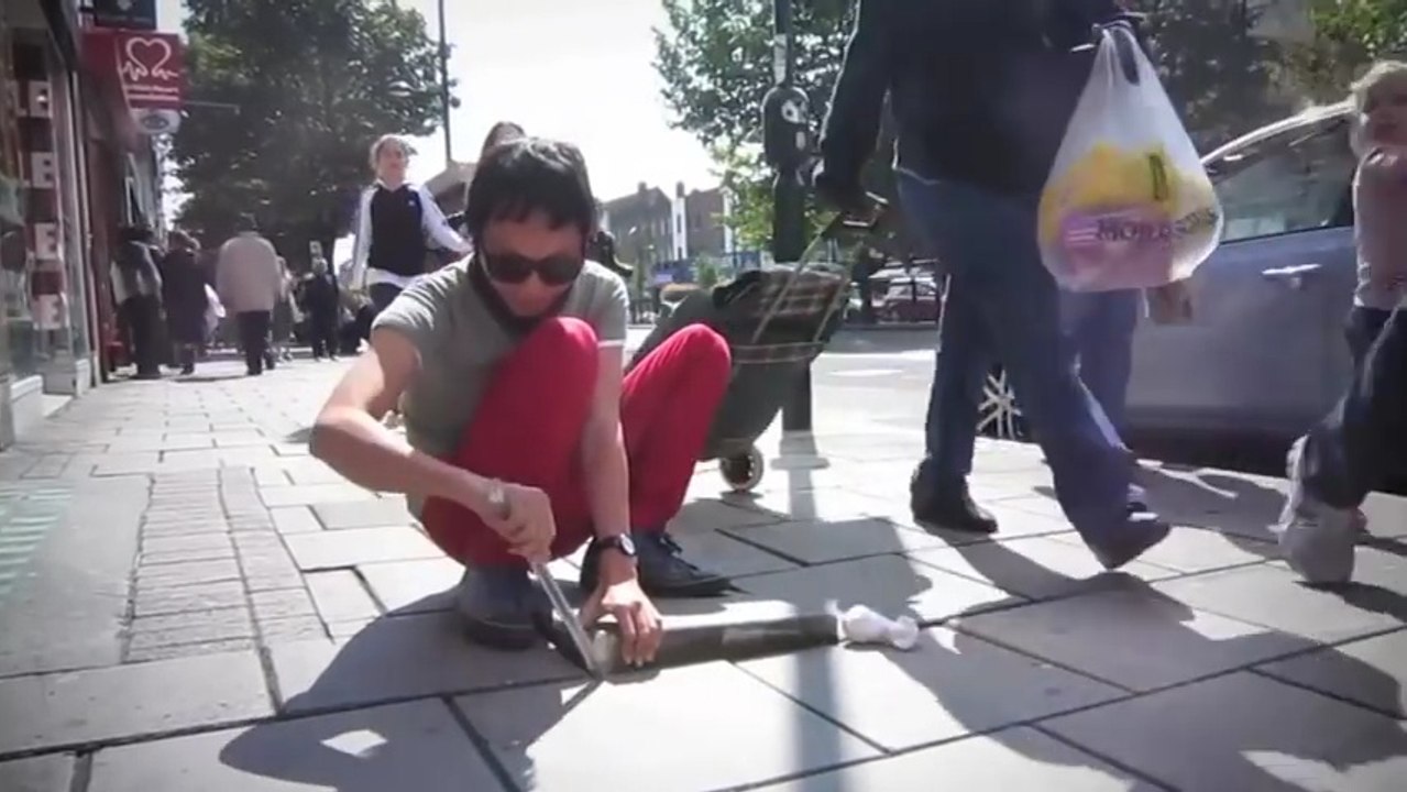 Glisser des jouets siffleurs sous les dalles du trottoir à Londres