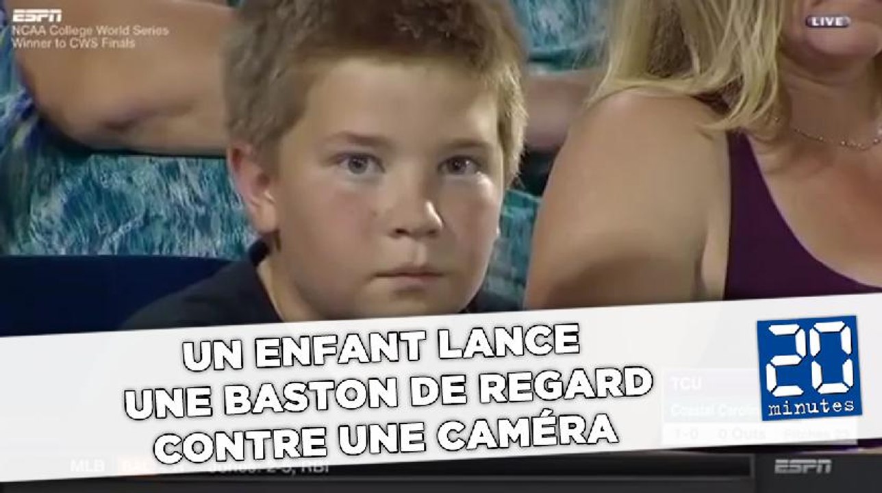 Un enfant lance  une baston de regard contre une caméra