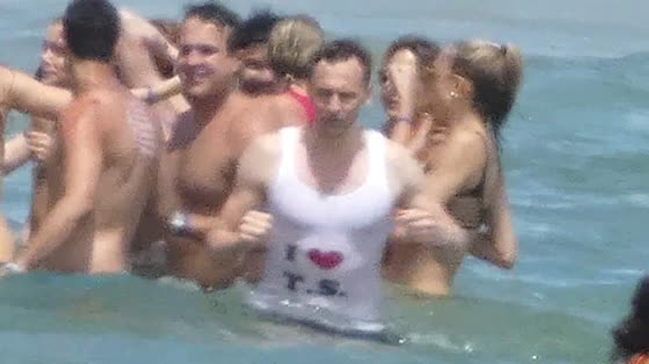 Warum trägt Tom Hiddleston ein 'Ich liebe Taylor Swift' Oberteil im Meer?