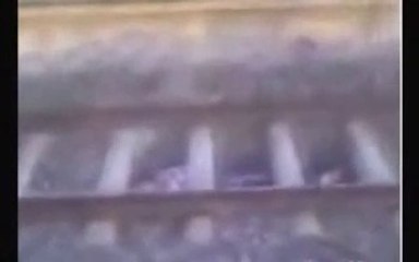 Kid hides under Train tracks