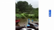 Groom picks up bride in rubber boat to cross flooded road