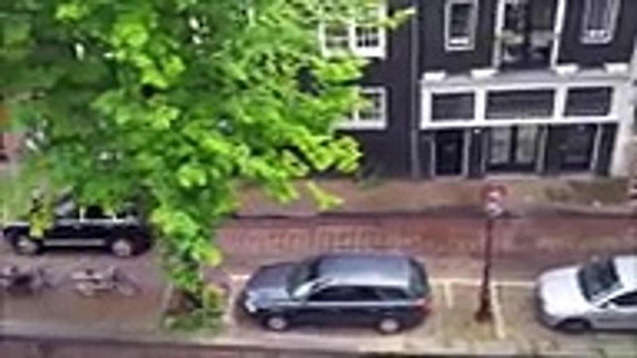 Pour le tournage d'un film une Porsche Cayenne pousse une voiture Smart dans un canal à Amsterdam.