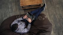 Man Lying In An Armchair, Holding a Laptop And Typing. - Stock Footage | VideoHive 15148527