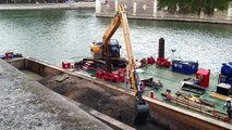 Aux pieds de Notre-Dame de Paris, une grue flottante s'emploie à nettoyer le fond de la Seine