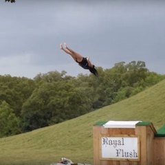 Uma mulher cai de costas retas ao sair de um tobogã aquático