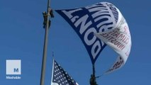 Title: Anti-Trump activists scale 60-foot flag poles outside Cleveland's Rock and Roll Hall of Fame