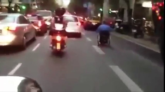 Hombre en silla de ruedas adelanta coches en Barcelona
