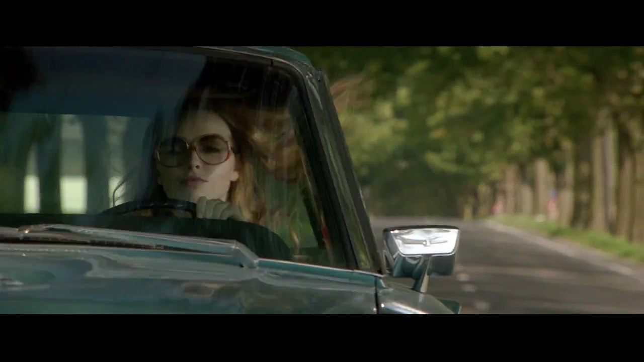 La dame dans l'auto avec des lunettes et un fusil