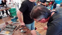 Dans le brouhaha des machines, Gérard apprend à fabriquer son propre couteau, épaulé par Jean, l'un des couteliers amateurs de l'atelier.
