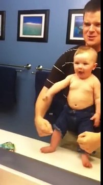 Baby adorably flexes muscles with dad