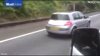 Woman reads her electricity bill while driving on the M5