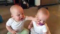 Twin baby girls fight over pacifier
