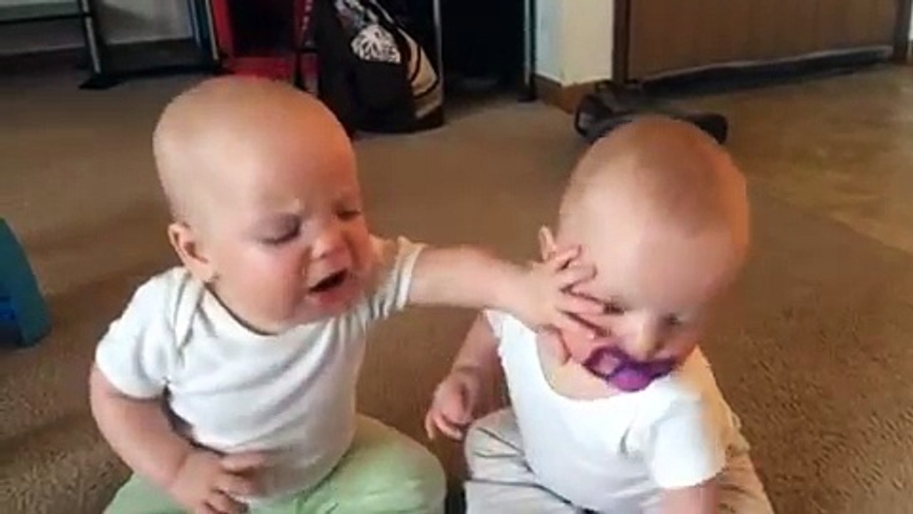 Twin baby girls fight over pacifier