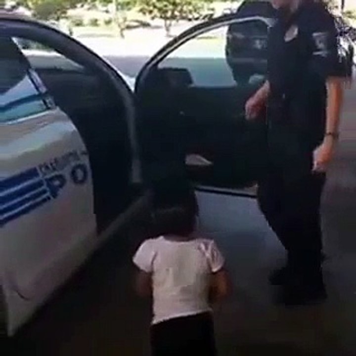 Une petite fille joue dans une voiture de police !