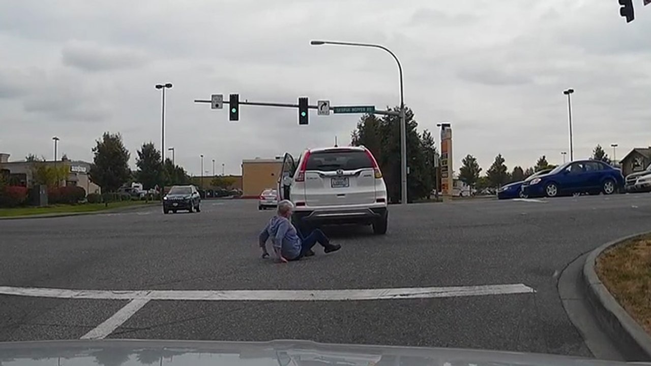 Une femme chute en voulant remonter dans sa voiture à une intersection