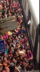 Des milliers de personnes sur le quai d'une gare se disputent pour monter dans le train