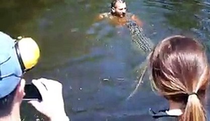 Guy jumps in river with crocodiles
