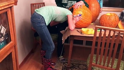 Une jeune fille se coince la tête dans une citrouille